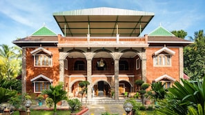 A two-story building with a central courtyard, featuring a covered walkway and multiple arches.