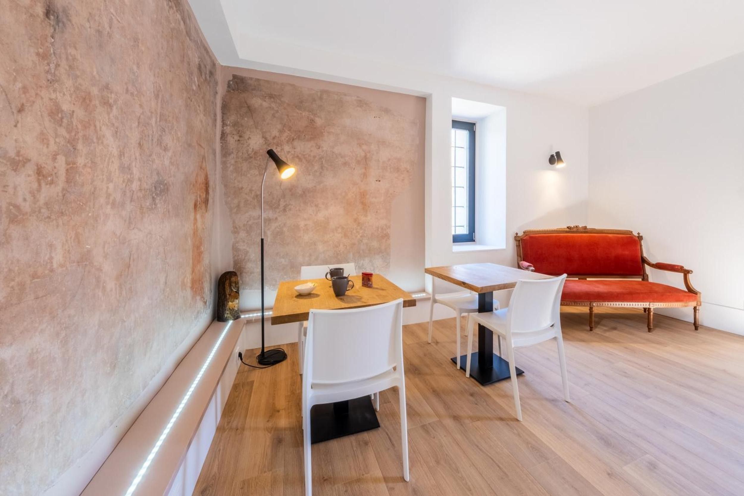 Un intérieur moderne avec un coin repas, un canapé rouge et une grande fenêtre.