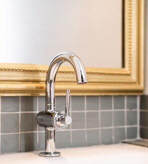 A chrome faucet with a single lever handle, mounted on a white countertop with a tiled backsplash. - Room 'Chambre La Poudriere' with Mountain View (Saint-Jean-de-Maurienne)