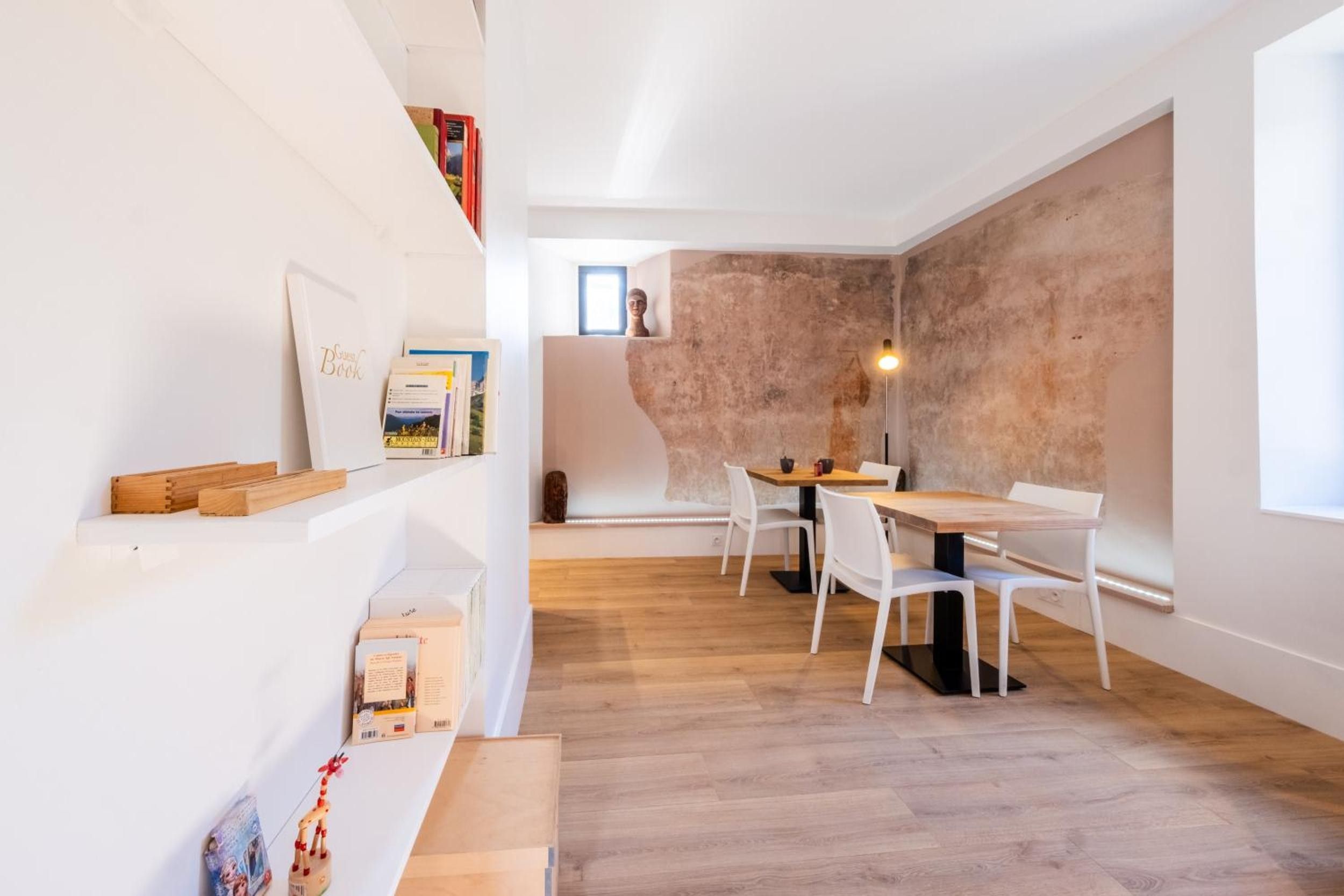 A modern interior with a dining area, white walls, and a textured wall feature.