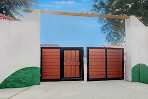 A gated entrance with a concrete wall and a wooden gate.