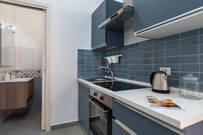Eine moderne Küche mit Einbauofen, Edelstahl-Dunstabzugshaube und einer Spüle mit zwei Becken.