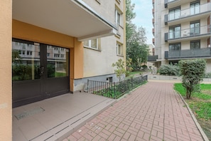 A residential building with a paved walkway, a black door, and a small tree. - Lumina 3 room Apart near Pałac Kultury (Warszawa)
