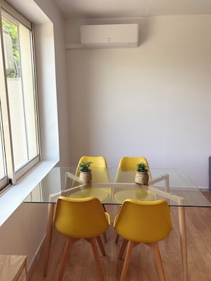 A modern meeting room with a glass table, yellow chairs, and a potted plant. - Balconies (Donzac)