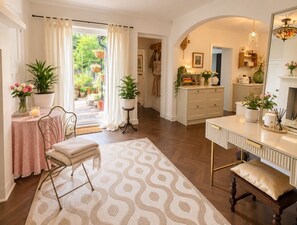 A well-lit room with a large window, a dining area with a table and chairs, a sofa, and a patterned rug. - Stunning detached 3-bed Country House (Plaistow)