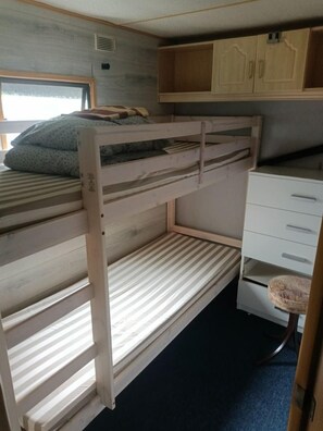 A bunk bed with a desk and drawers, a window, and a door. - Gezinsvakantie in de Drentse natuur | Stacaravan (Wijster)