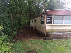 Una casa mobile con veranda coperta e un piccolo giardino.