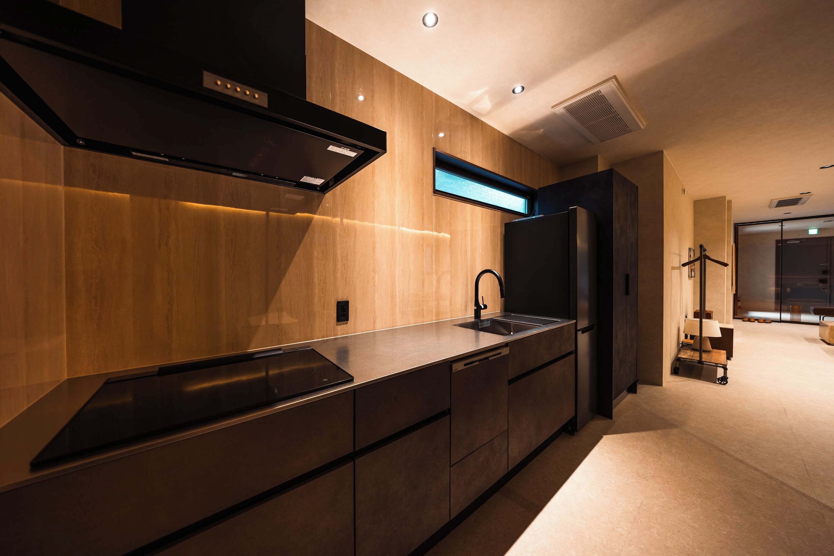 A modern kitchen with a built-in stove, a sink, and a range hood.