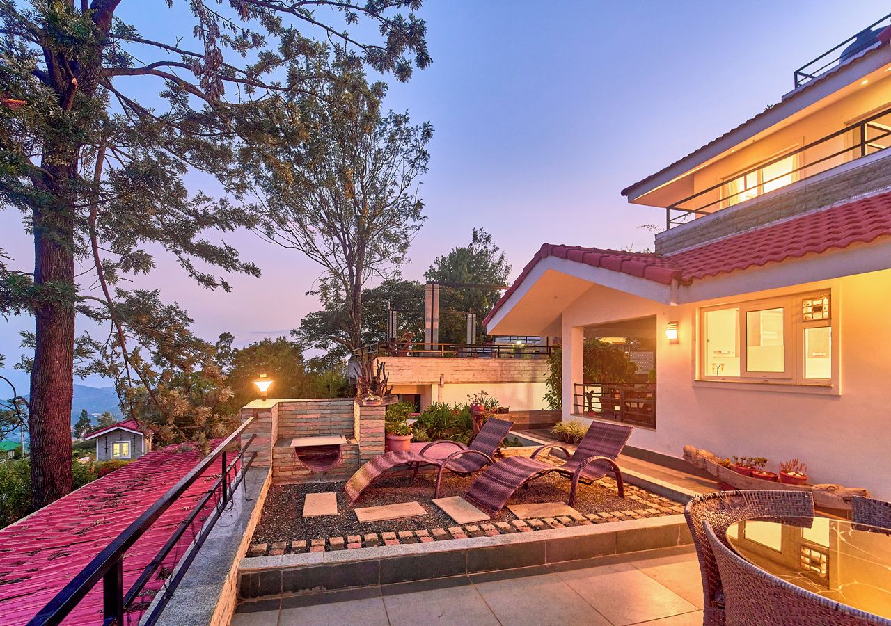 Uma casa moderna com um pátio, móveis de exterior e vista para a paisagem ao redor.