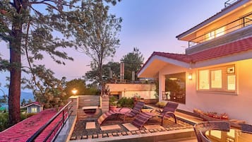 Uma casa moderna com um pátio, móveis de exterior e vista para a paisagem ao redor.