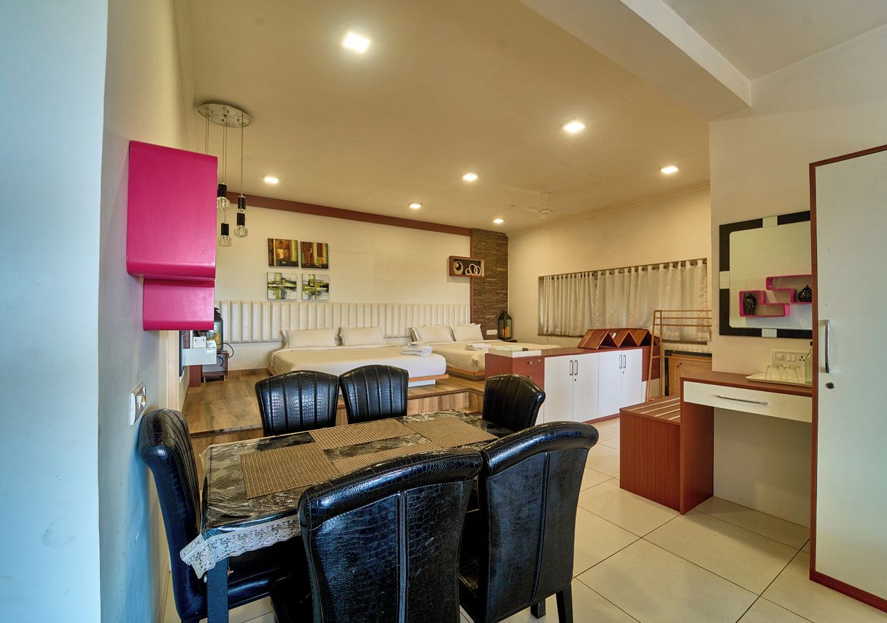 A compact living space with a dining area, a kitchenette, and a seating area with a sofa and a coffee table.