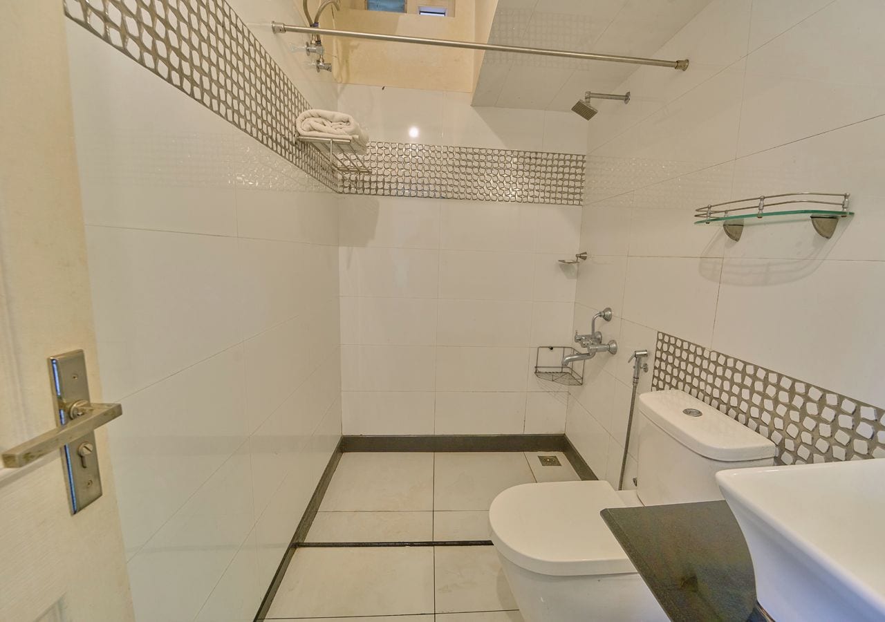 A bathroom with a shower, toilet, and sink.