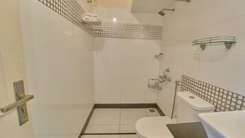 A bathroom with a shower, toilet, and sink.