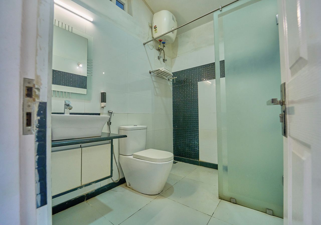 A bathroom with a toilet, sink, and shower area.