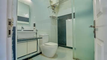 A bathroom with a toilet, sink, and shower area.
