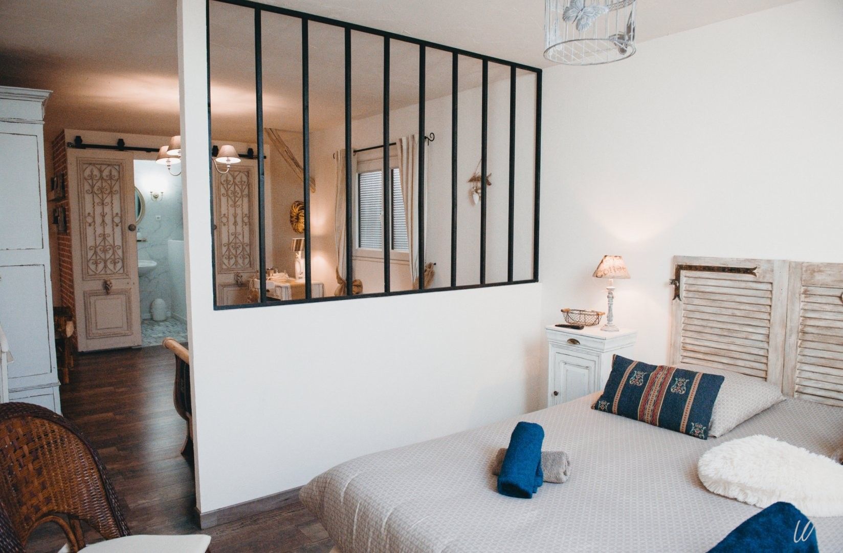 Une chambre à coucher avec un lit, une table de chevet, une commode et un miroir.