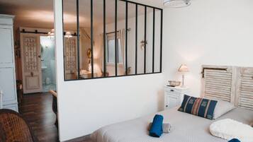 Une chambre à coucher avec un lit, une table de chevet, une commode et un miroir.