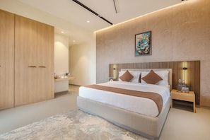 Un dormitorio moderno con una cama grande, un armario, mesitas de noche y un cuadro en la pared.