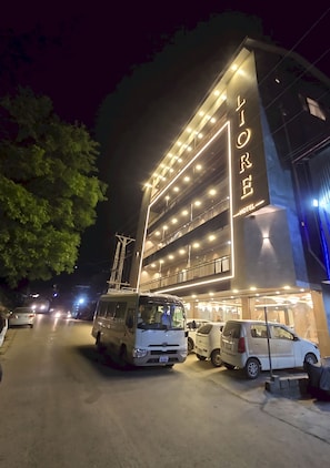 Un hotel de diseño moderno, con varios pisos y una fachada bien iluminada.