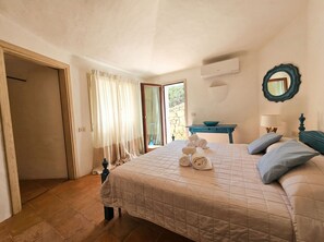 A hotel room with a bed, a table, a mirror, and a view of the outdoors. - Villa Marina – Front Marina Luxury Living in Porto Cervo (Porto Cervo)