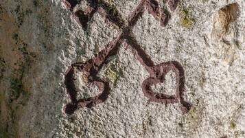 A close-up of a wall with a weathered inscription, including the numbers '1847' and a stylized 'X' symbol.