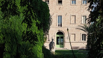 Un edificio histórico con un patio, una estatua y un estanque.