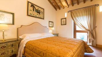 A bedroom with a large bed, wooden headboard, and a window with curtains.