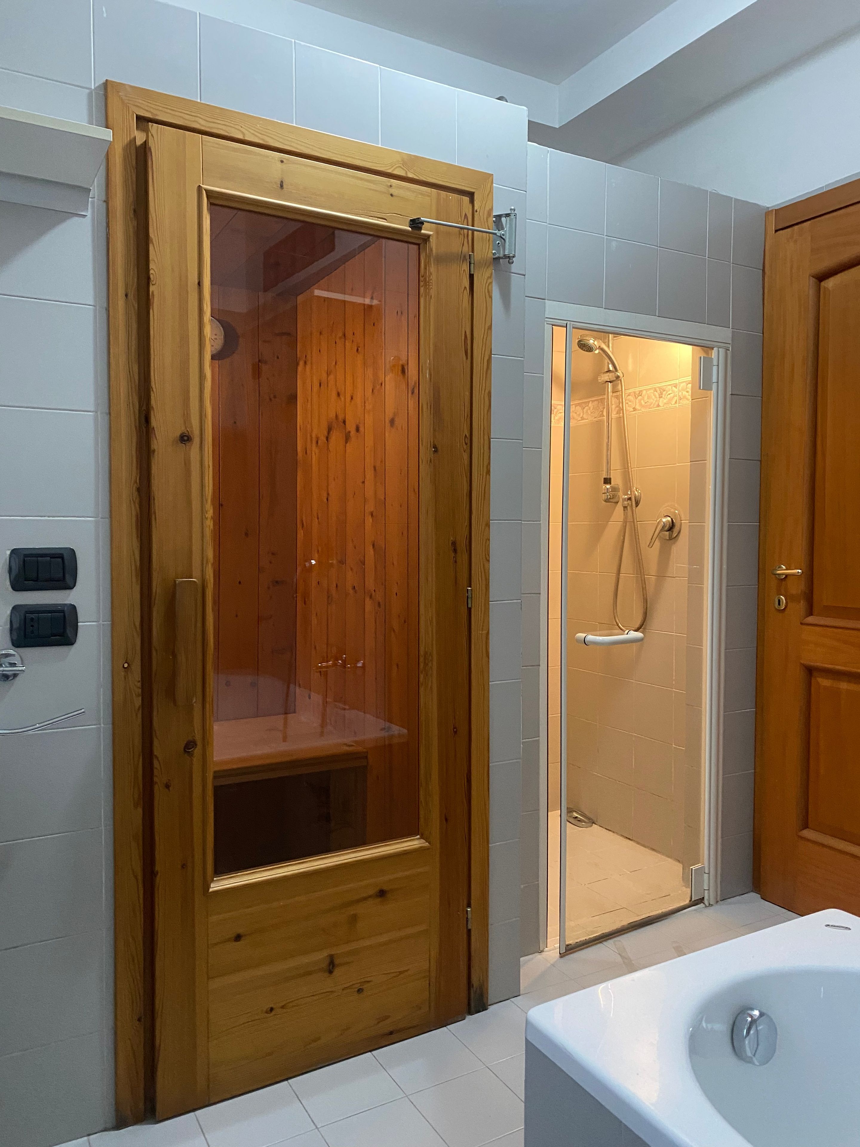 Ein Badezimmer mit einer Duschkabine aus Holz, einer Badewanne und einer Toilette.
