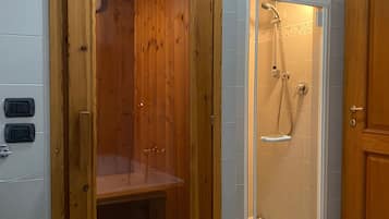Ein Badezimmer mit einer Duschkabine aus Holz, einer Badewanne und einer Toilette.