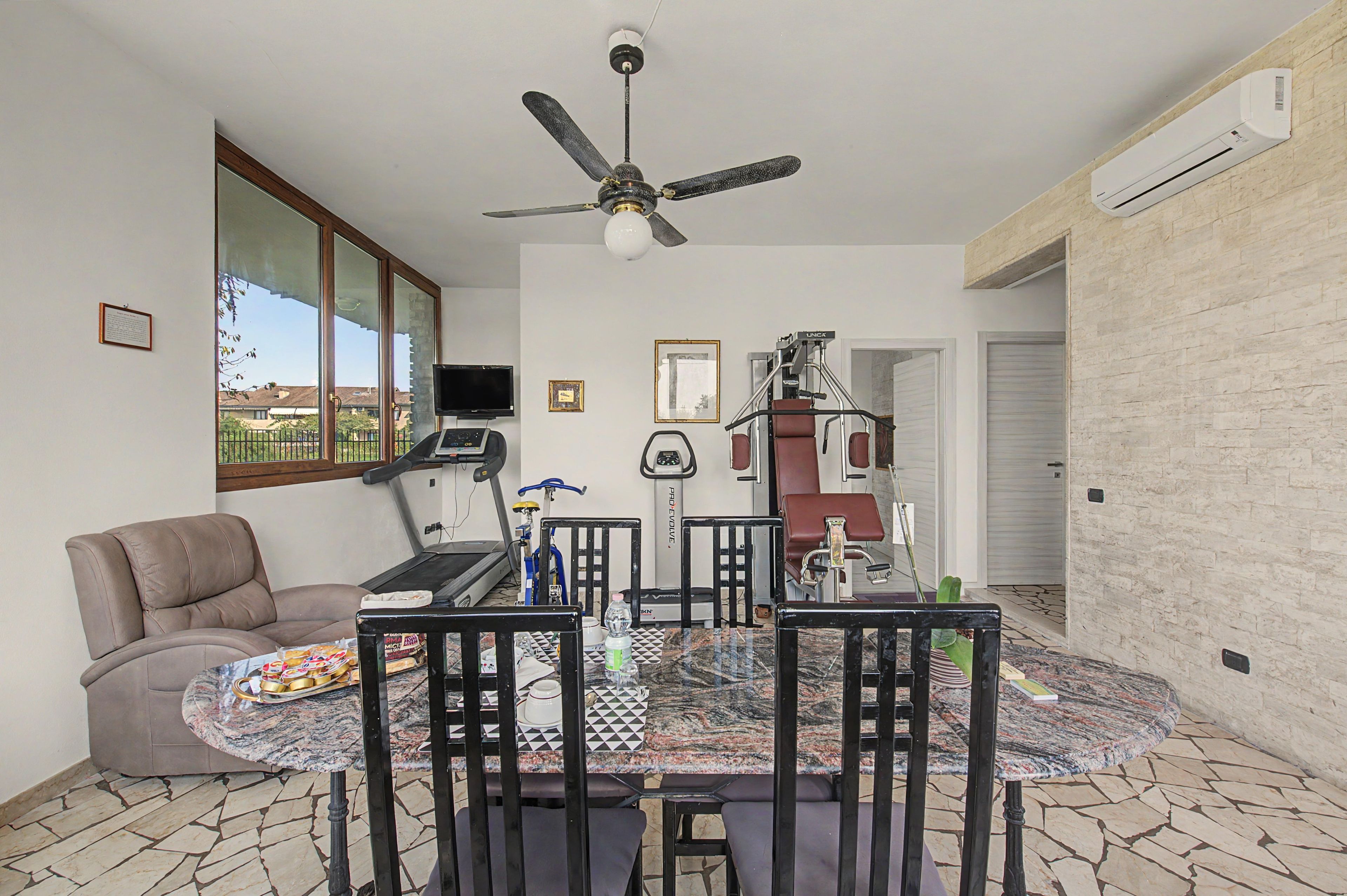 Un comedor con una mesa, sillas y un ventilador de techo.