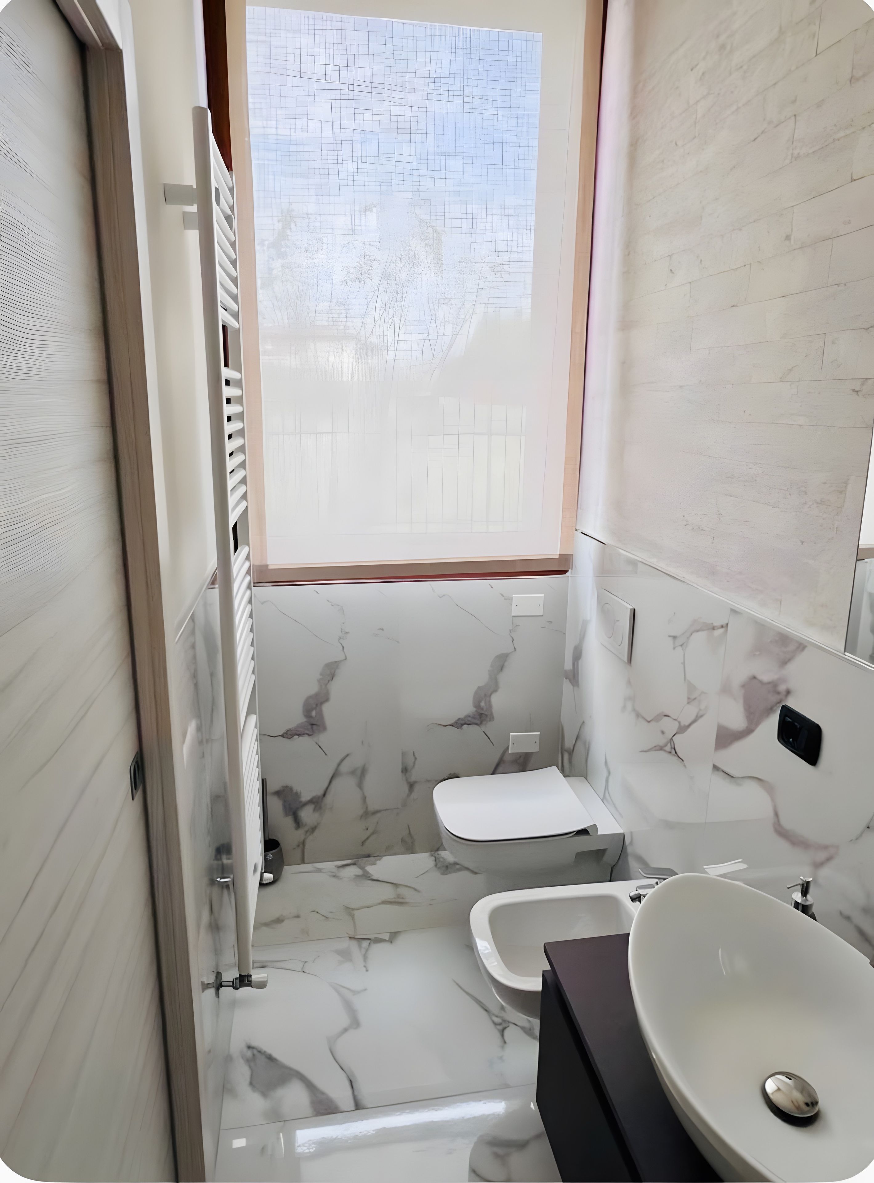 Een badkamer met toilet, wastafel en bidet.