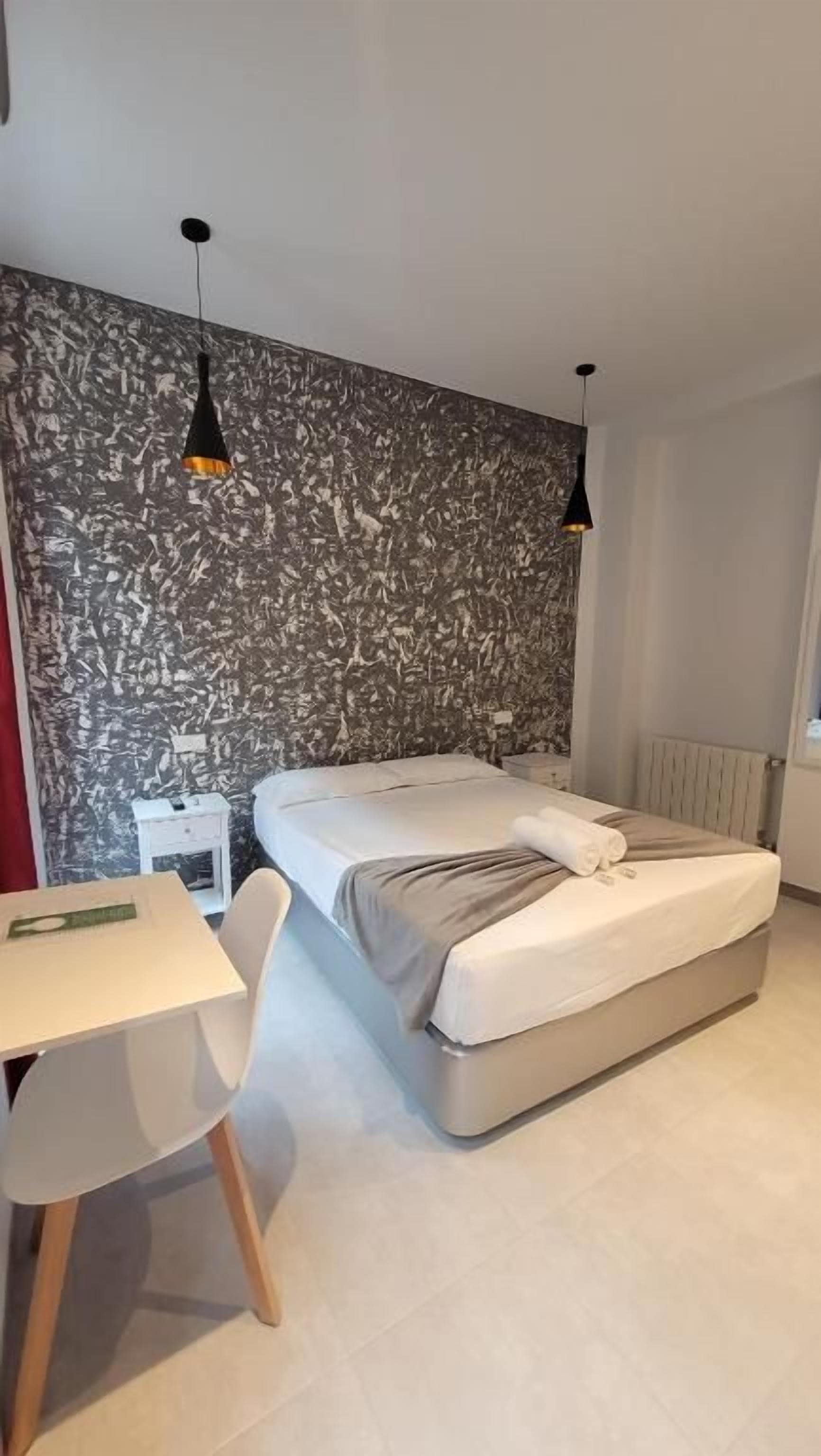 Un dormitorio con una cama, un escritorio y una silla.