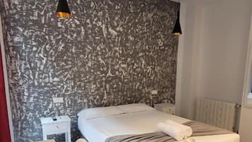 Un dormitorio con una cama, un escritorio y una silla.