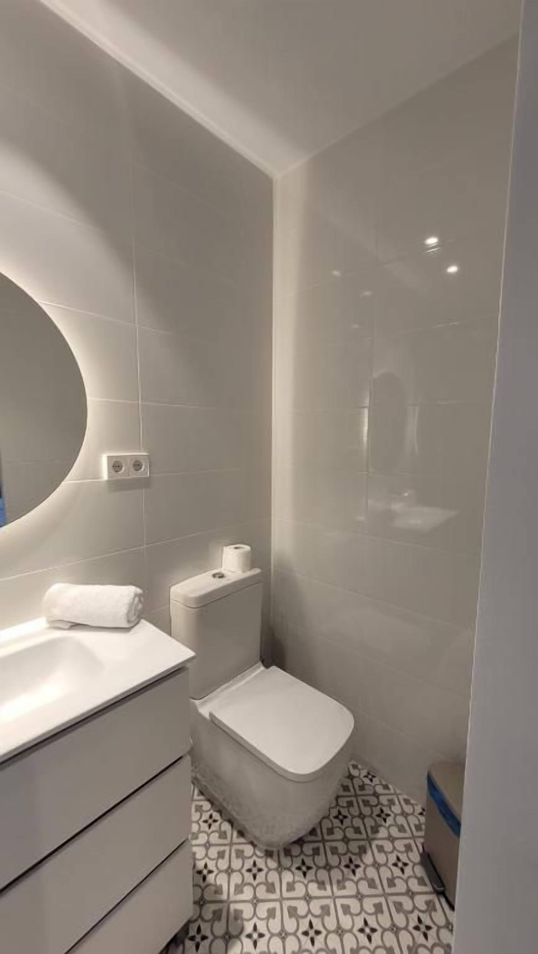 A bathroom with a toilet, bidet, and a sink.
