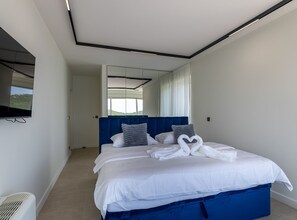 A modern bedroom with a large bed, a mirror, and a view of the outdoors. - Villas Mr&mrs Smith (Slivno)