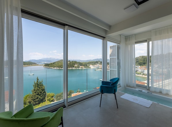 A spacious balcony with a clear view of a lake and mountains.