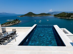 An infinity pool with a clear view of a calm sea and distant islands. - Villas Mr&mrs Smith (Slivno)
