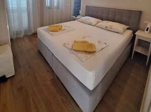A neatly made bed with two pillows and two folded towels. - Villa Lili (Murter-Kornati)