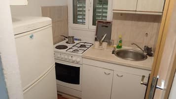 Una cocina compacta con estufa, horno, pileta y placares.