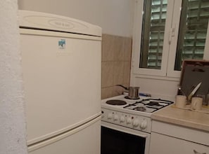 Una cocina con refrigerador, estufa y horno blancos.