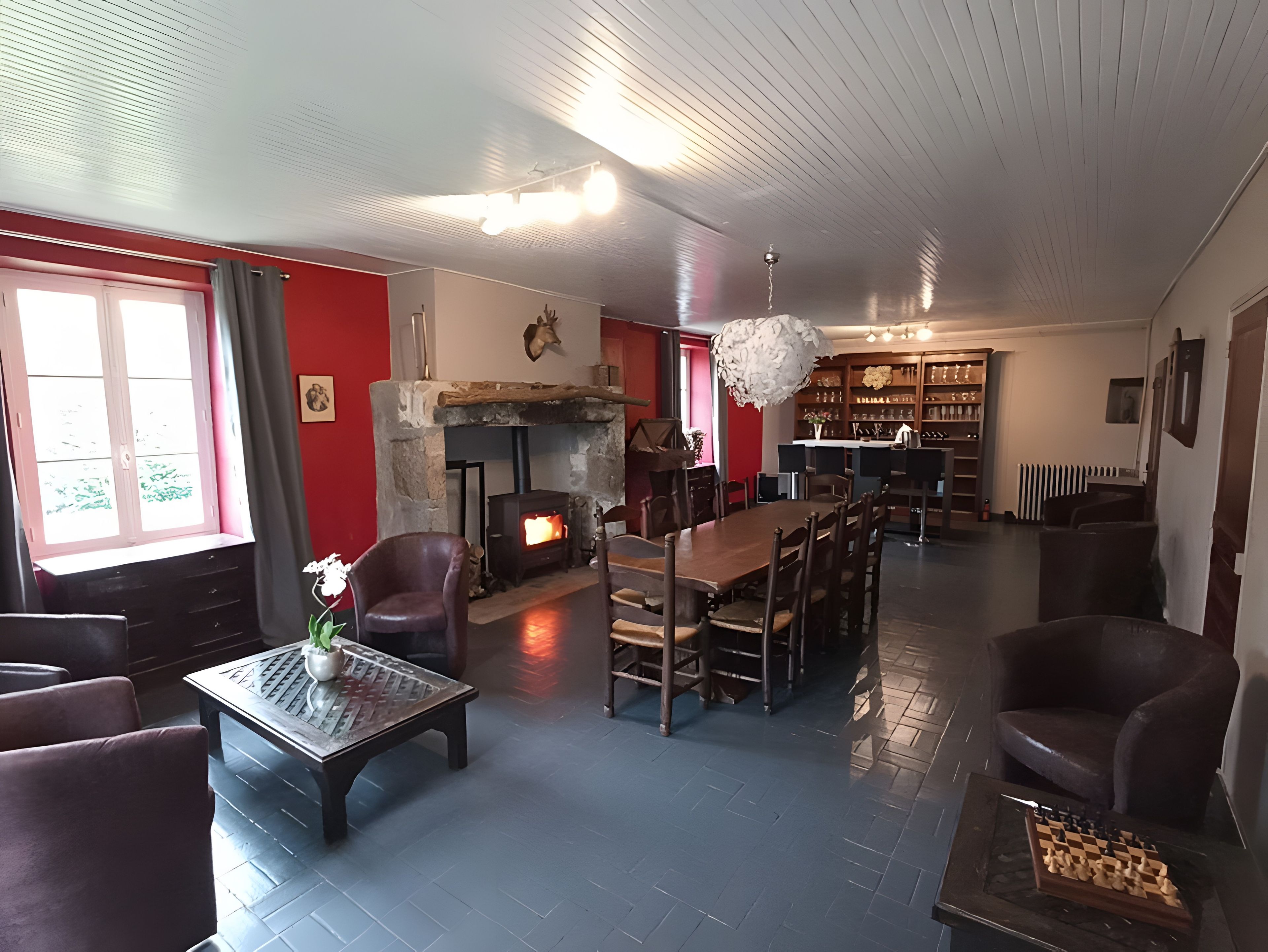 Un salon chaleureux avec une cheminée, un coin repas et une bibliothèque.