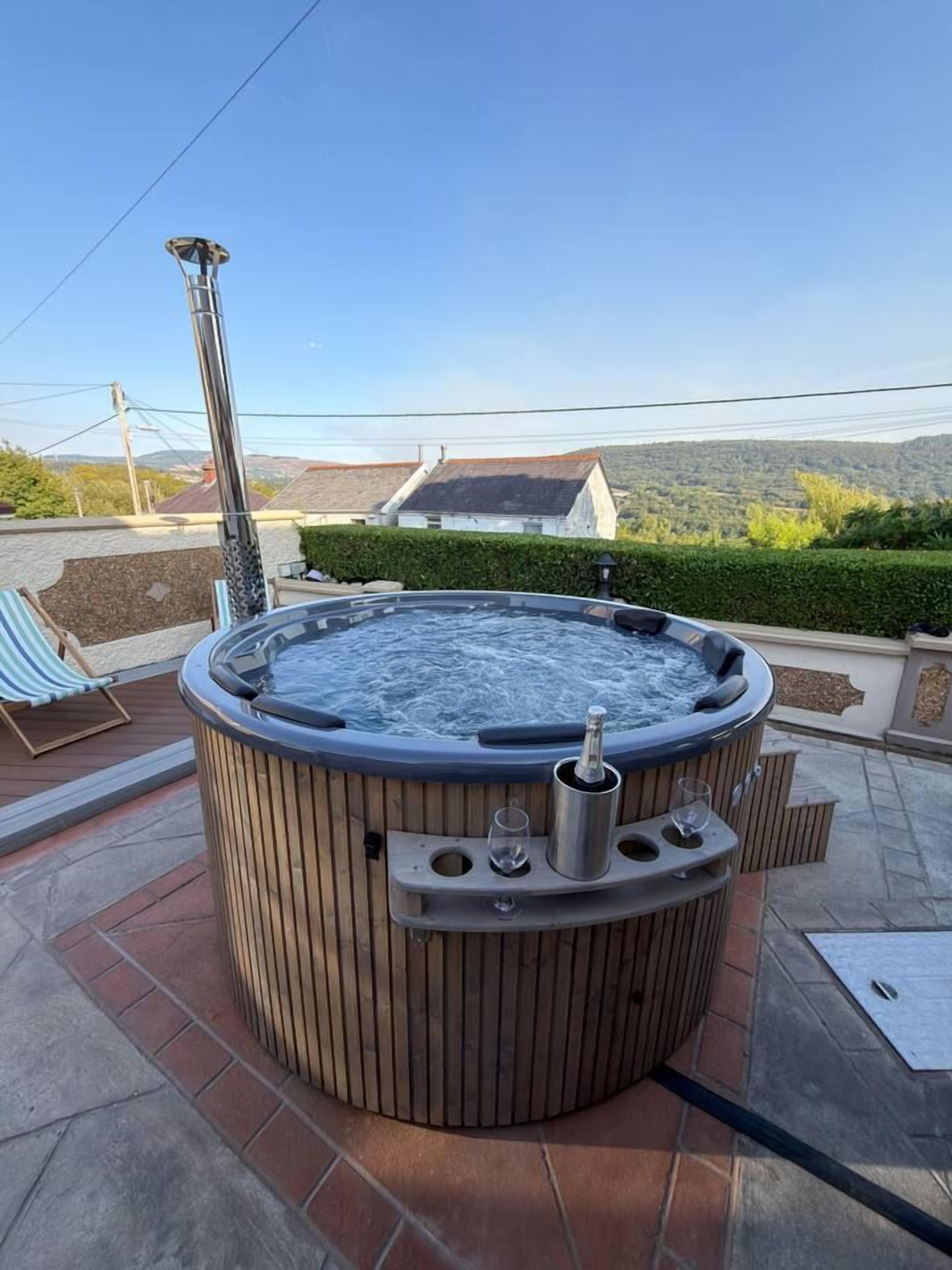 Ein Whirlpool auf einer Terrasse mit freiem Blick auf die umliegende Landschaft.