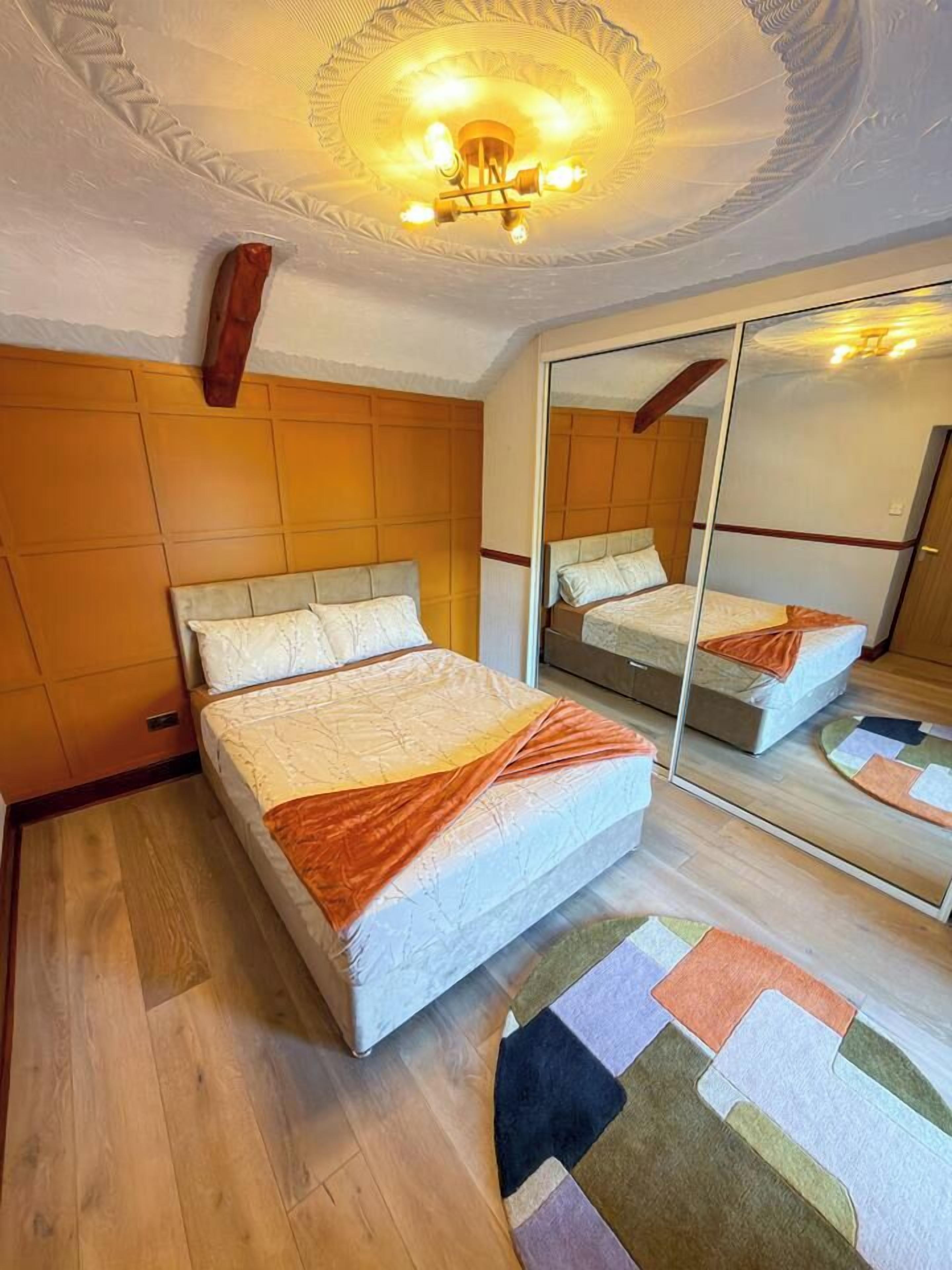 Ein Hotelzimmer mit einem Bett, einem Spiegel und einem hölzernen Kopfteil.