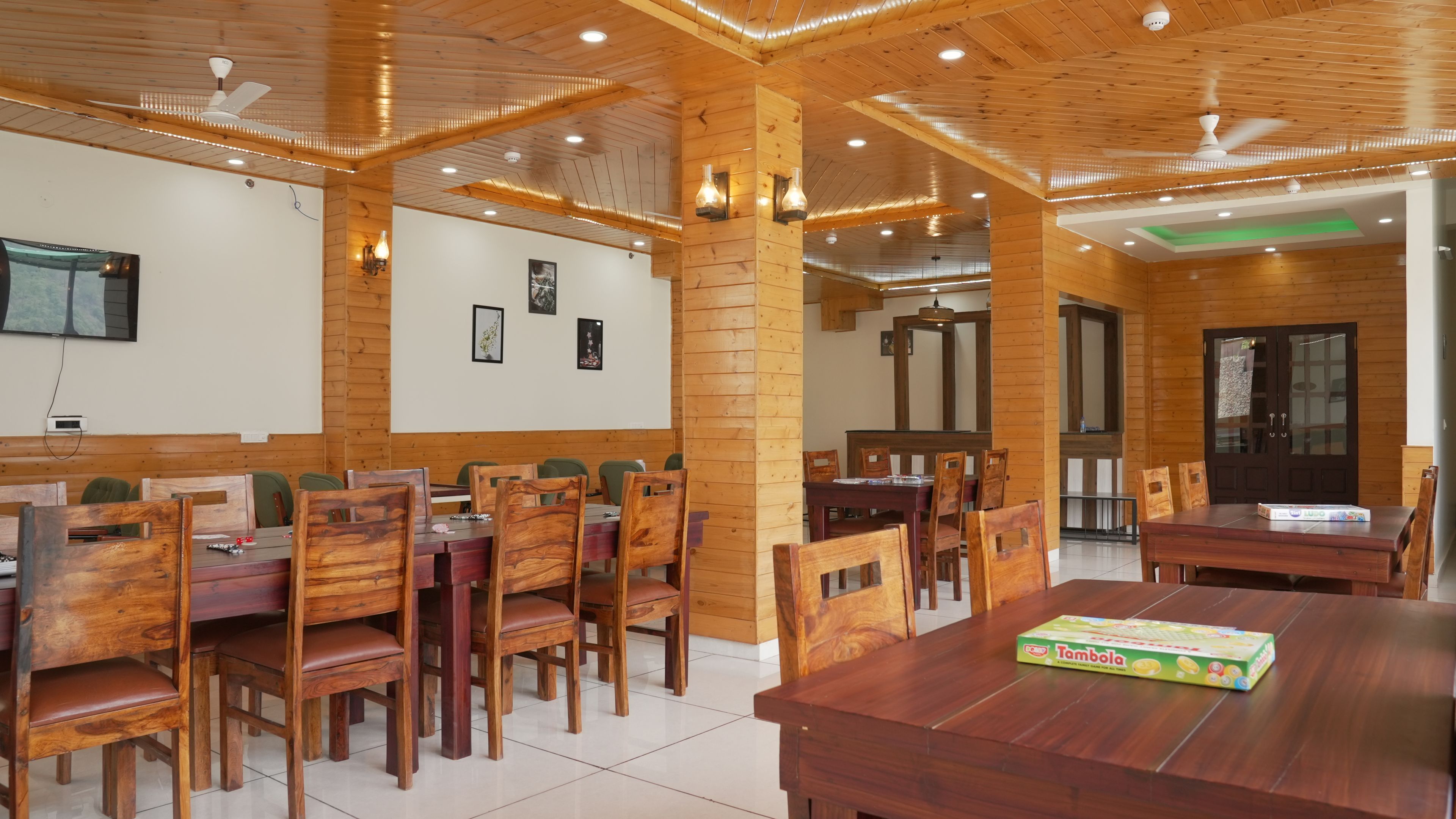 A dining area with wooden furniture and ceiling fans.