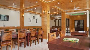 A dining area with wooden furniture and ceiling fans.