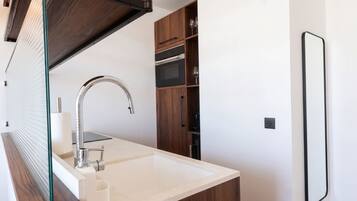 A modern bathroom with a white sink, chrome faucet, and wooden cabinets.