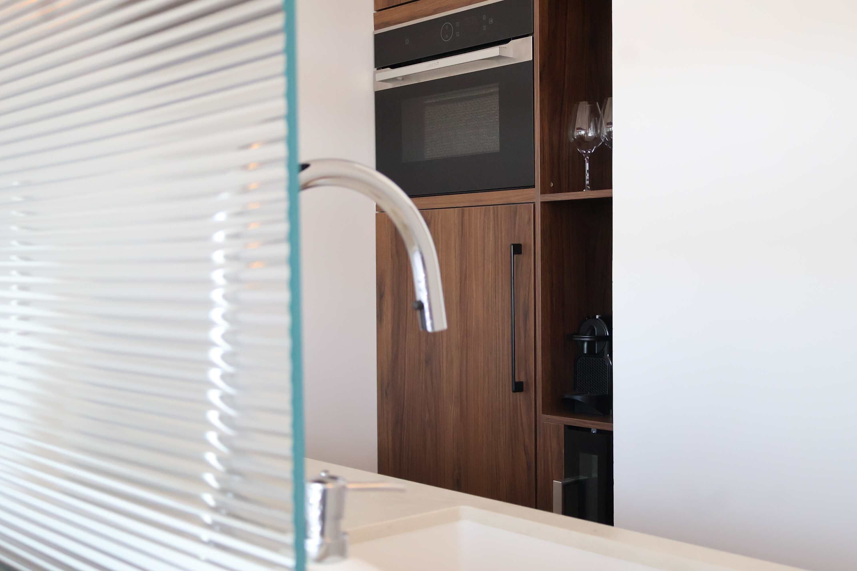 Une salle de bain dotée d’un lavabo moderne, d’une douche en verre et de meubles en bois.