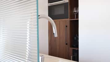 Une salle de bain dotée d’un lavabo moderne, d’une douche en verre et de meubles en bois.