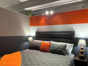 Een moderne slaapkamer met een groot bed, twee bedlampen en een opvallend wandontwerp.