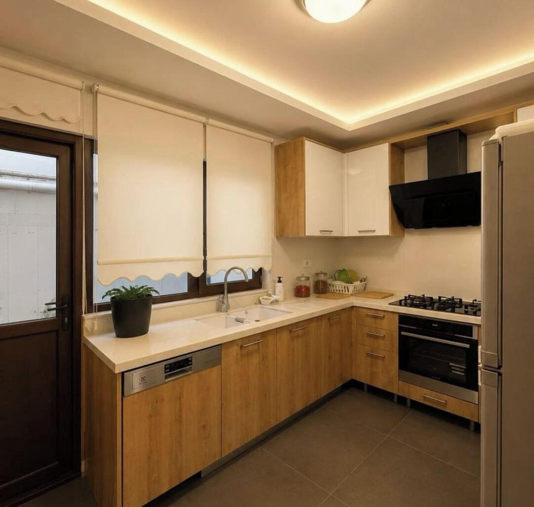 Eine moderne Küche mit Holzausstattung, Spülmaschine, Herd und Mikrowelle.